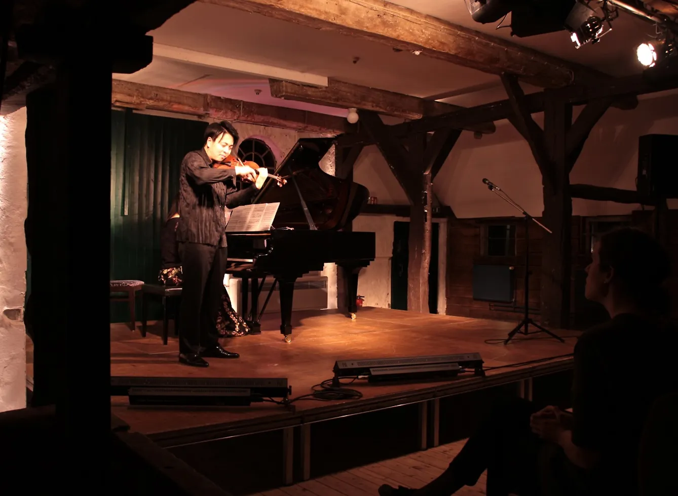 Ein Violinist auf der Bühne im Pferdestall.