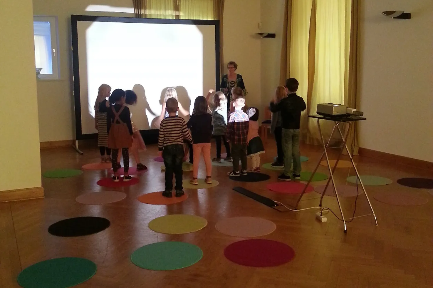 Eine Gruppe von Kindern vor einer großen Leinwand.
