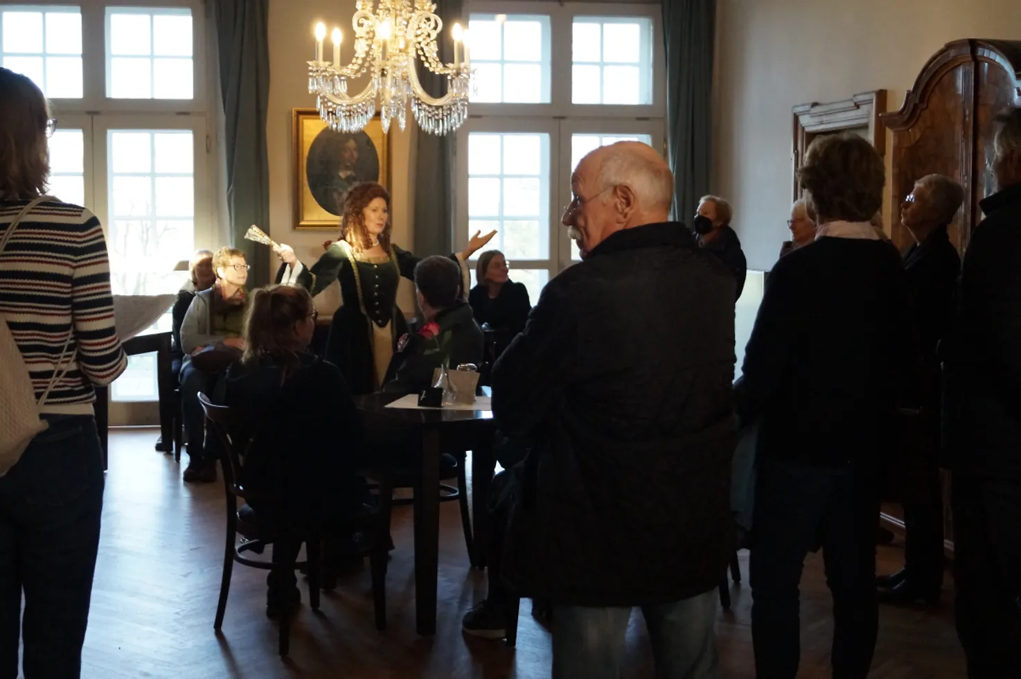 Eine Gästeführerin in historischem Gewand begrüßt eine Gruppe auf Schloss Agathenburg