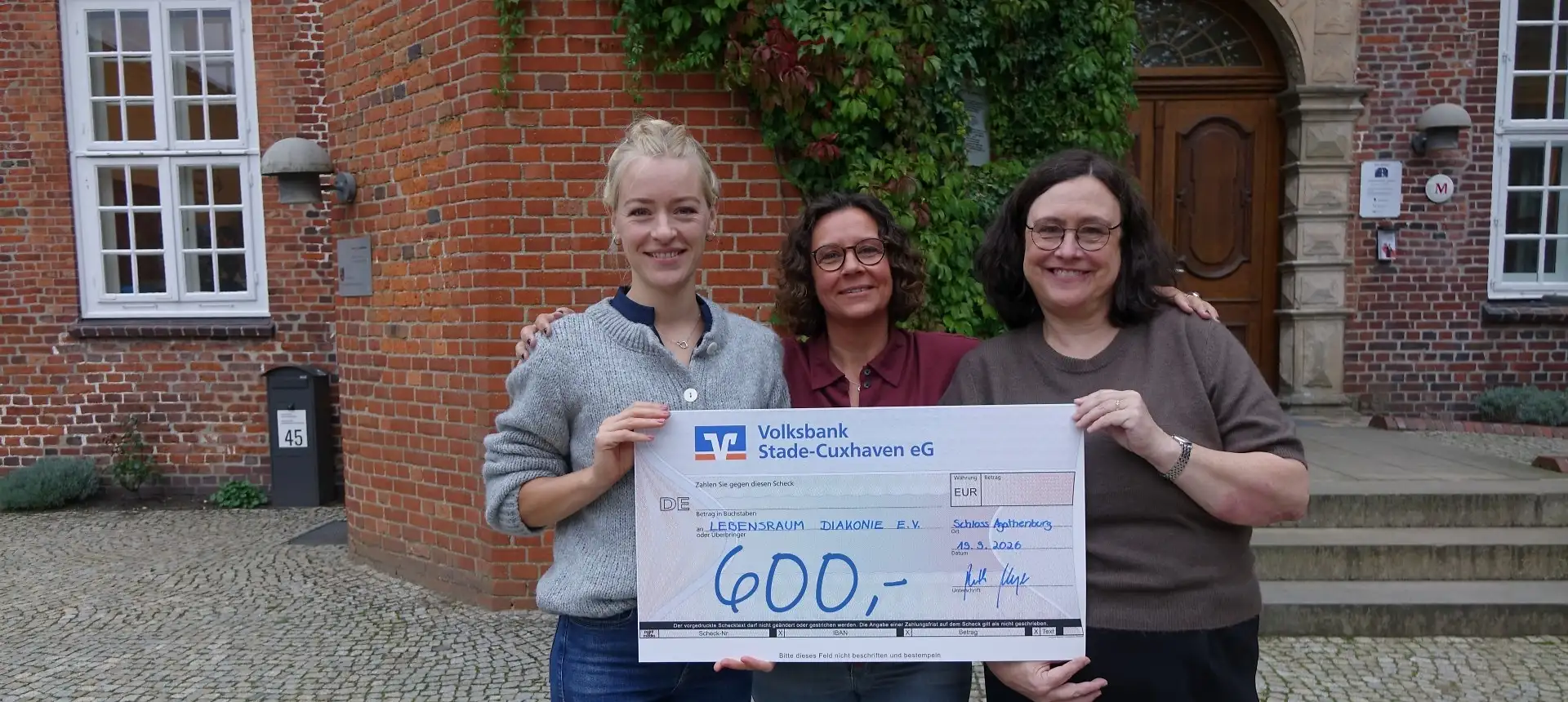 Foto Übergabescheck mit den drei Organisatorinnen