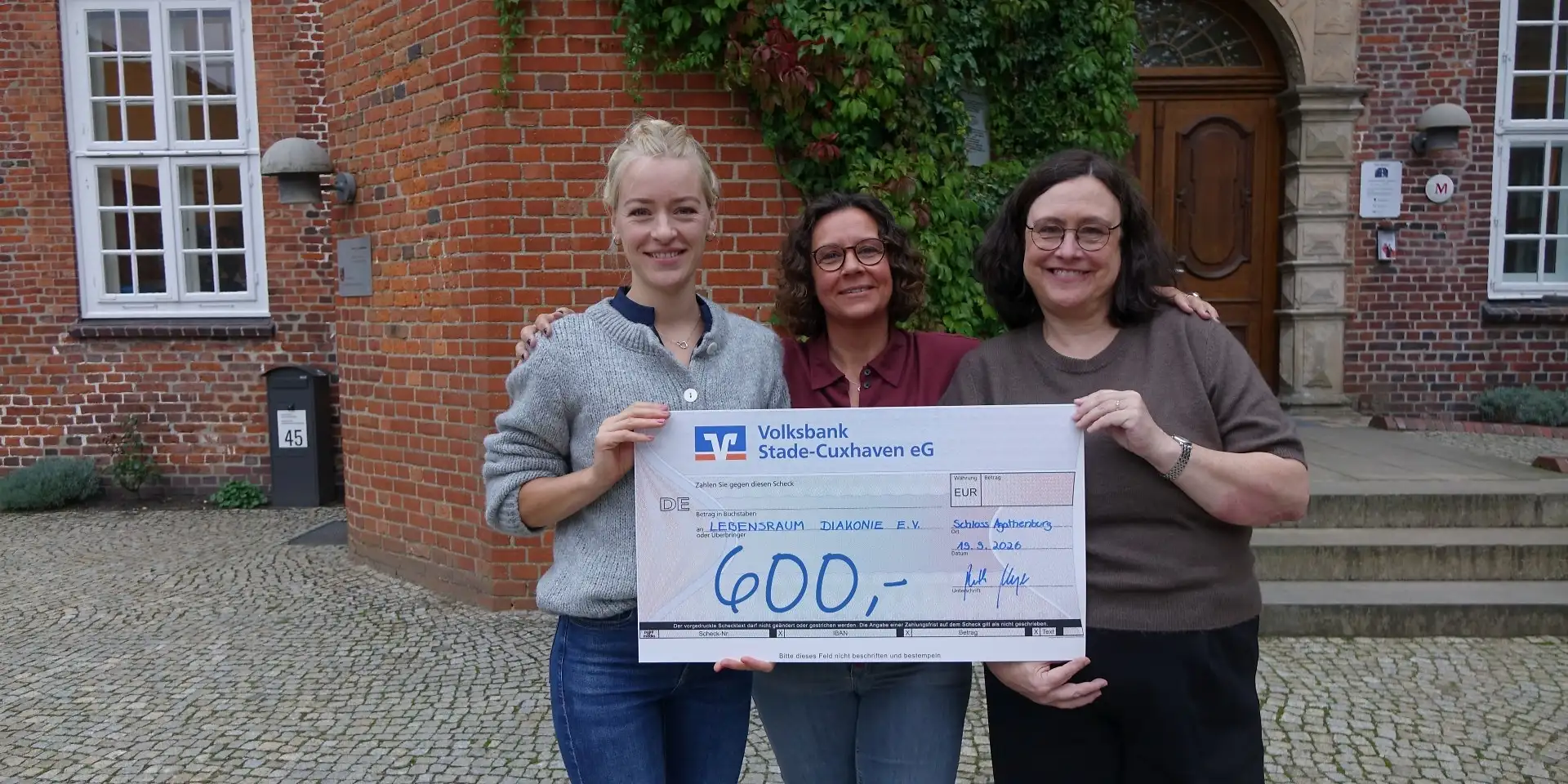 Foto Übergabescheck mit den drei Organisatorinnen