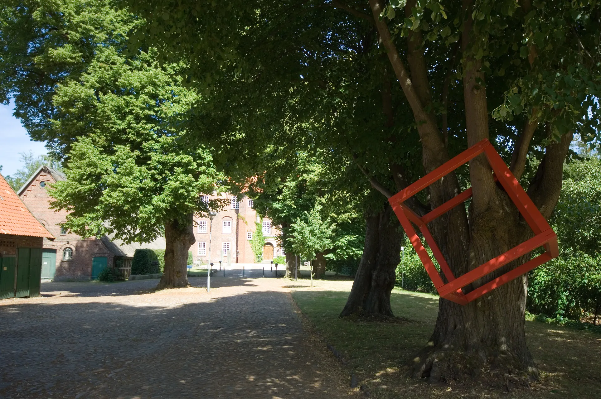 Eine alte Allee und ein roter Kubus