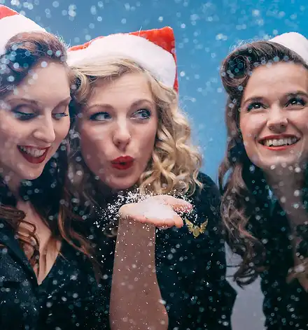 Die drei Sängerinnen mit Weihnachtsmützen.