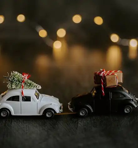 Weihnachten nach Hause Zwei weihnachtlich beladene Spielzeugautos