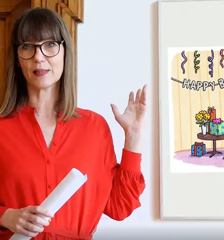 Art & Aperitif Claudia Rasztar zeigt auf eine gerahmte Karikatur.