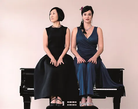 Jeong-Min Kim und Franziska Dannheim sitzen in Abendkleidern auf dem Flügel. 