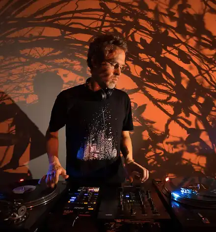 ...and the sun goes down DJ mit Pult, Lichtprojektion im Hintergrund