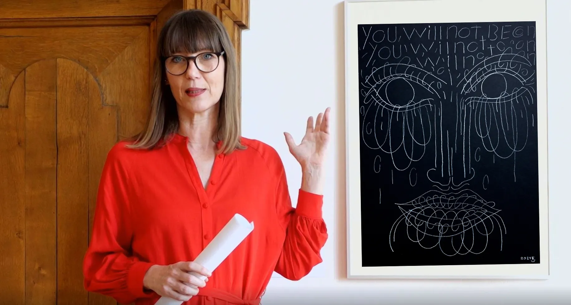 Claudia Rasztar zeigt auf ein Bild