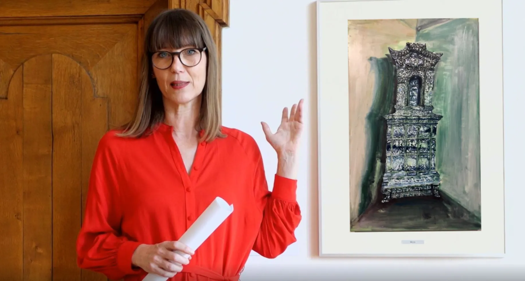 Claudia Rasztar zeigt auf ein gerahmtes Bild