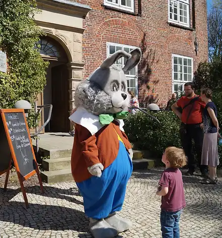 Osterhase und kleiner Junge vor Schloss Agathenburg