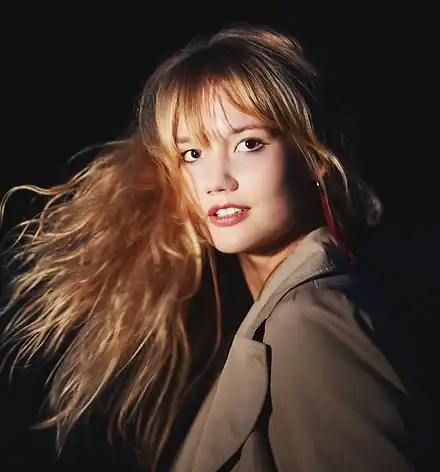 Fabia Mantwill Quintet - Sasa Ndio Sasa Ein Porträt von Fabia Mantwill. Die junge Frau ist vor einem schwarzen Hintergrund fotografiert und schwingt ihr langes blondes Haar.