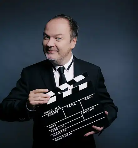 Jens Wawrczeck mit einer Filmklappe