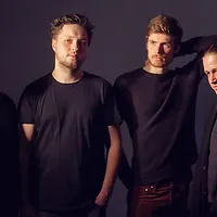 Campus Jazz - Best of HMTMH Foto der vier Musiker, alle in schwarz vor schwarzem Hintergrund