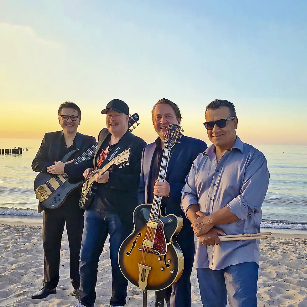 Gruppenbild der vier Musiker am Strand.