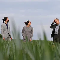 Campus Jazz Foto des Trios auf einer grünen Wiese.