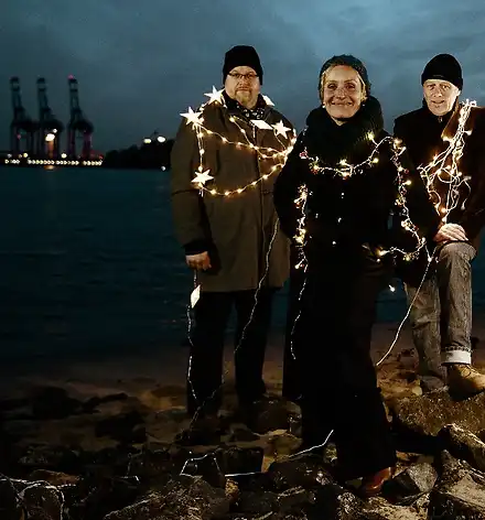 Trio Hafennacht mit Lichterketten umwickelt bei Dämmerung im Hamburger Hafen