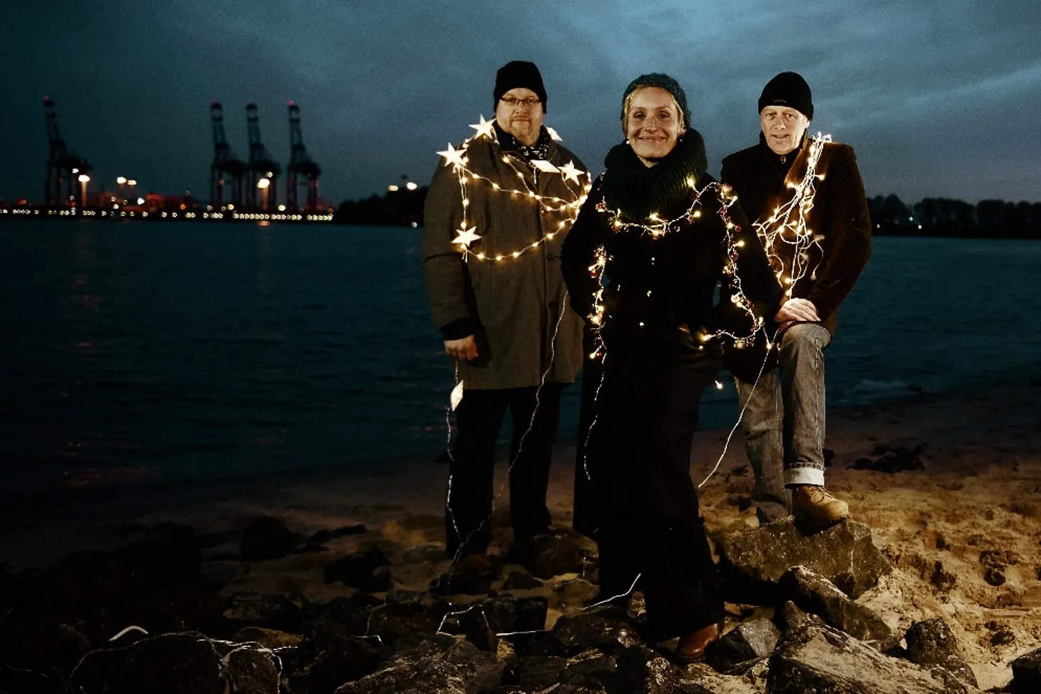 Trio Hafennacht mit Lichterketten umwickelt bei Dämmerung im Hamburger Hafen