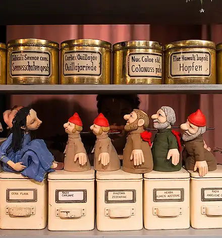 Handpuppen (Schneewittchen und die sieben Zwerge) in einem Apothekerregal