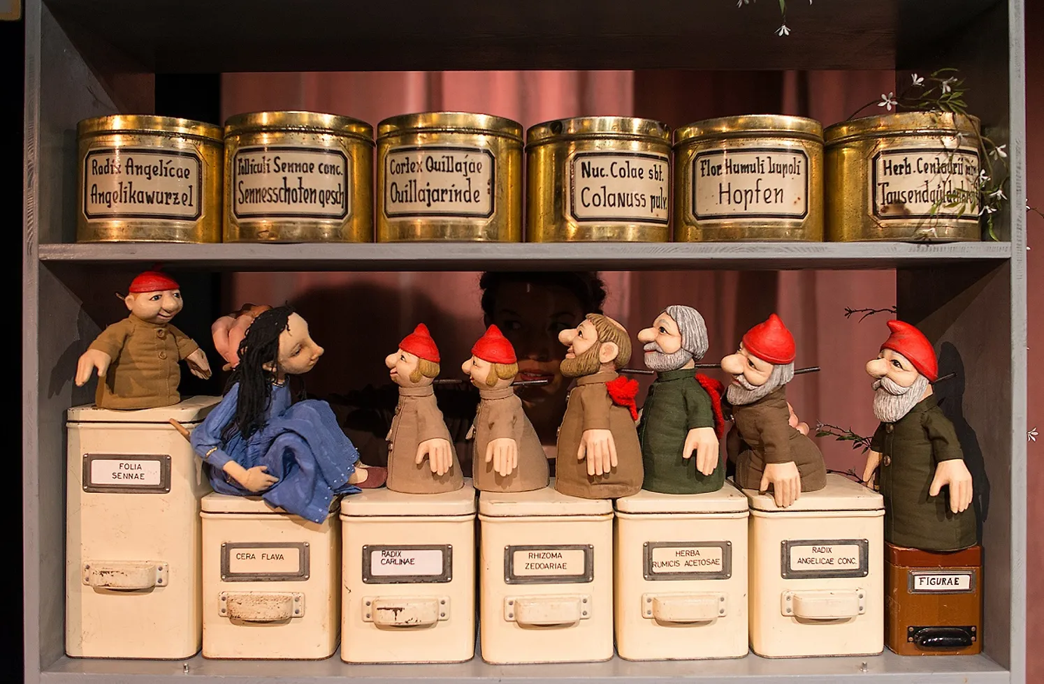 Handpuppen (Schneewittchen und die sieben Zwerge) in einem Apothekerregal