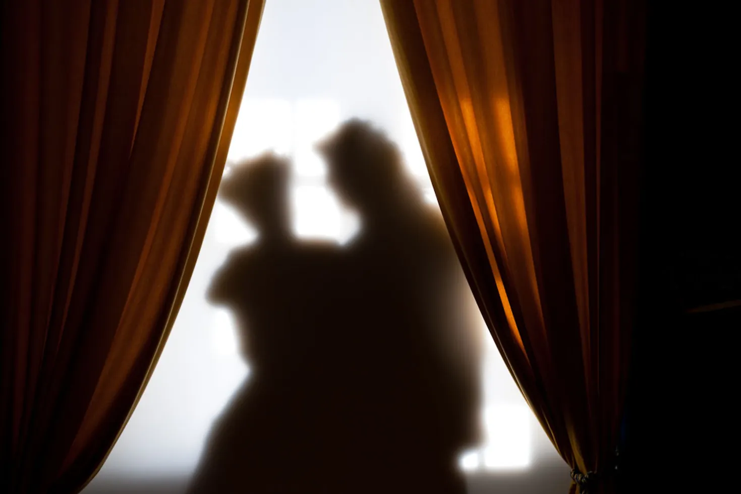 Die Silhouetten eines Liebespaars am Fenster.